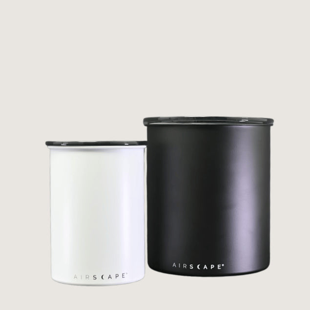 Two Airscape coffee containers black and white of different sizes stand next to eachtother